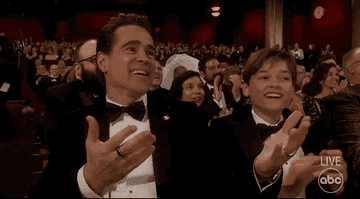 GIF of Colin Farrell and his son applauding and smiling