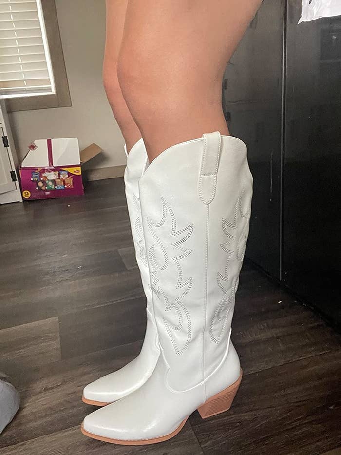 reviewer wearing the white cowboy boots