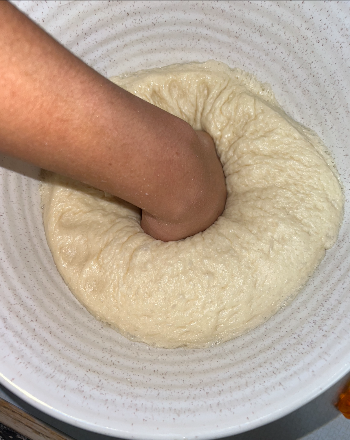 A fist punching the dough