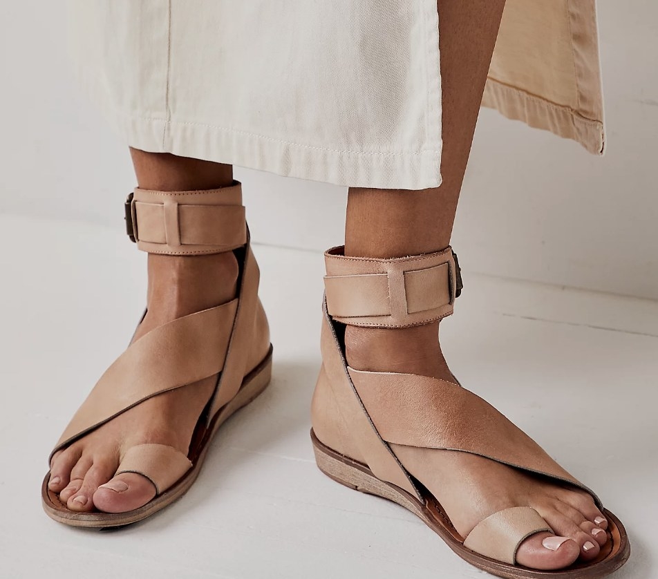 Someone&#x27;s feet wearing a pair of the sandals in a light brown color