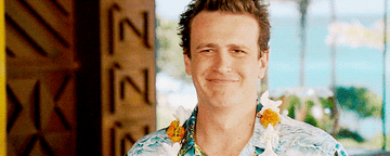 A man in a lei and Hawaiian shirt.