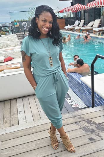 Reviewer's photograph of them wearing the jumpsuit successful the colour Teal, styled with connection jewelry and bully sandals