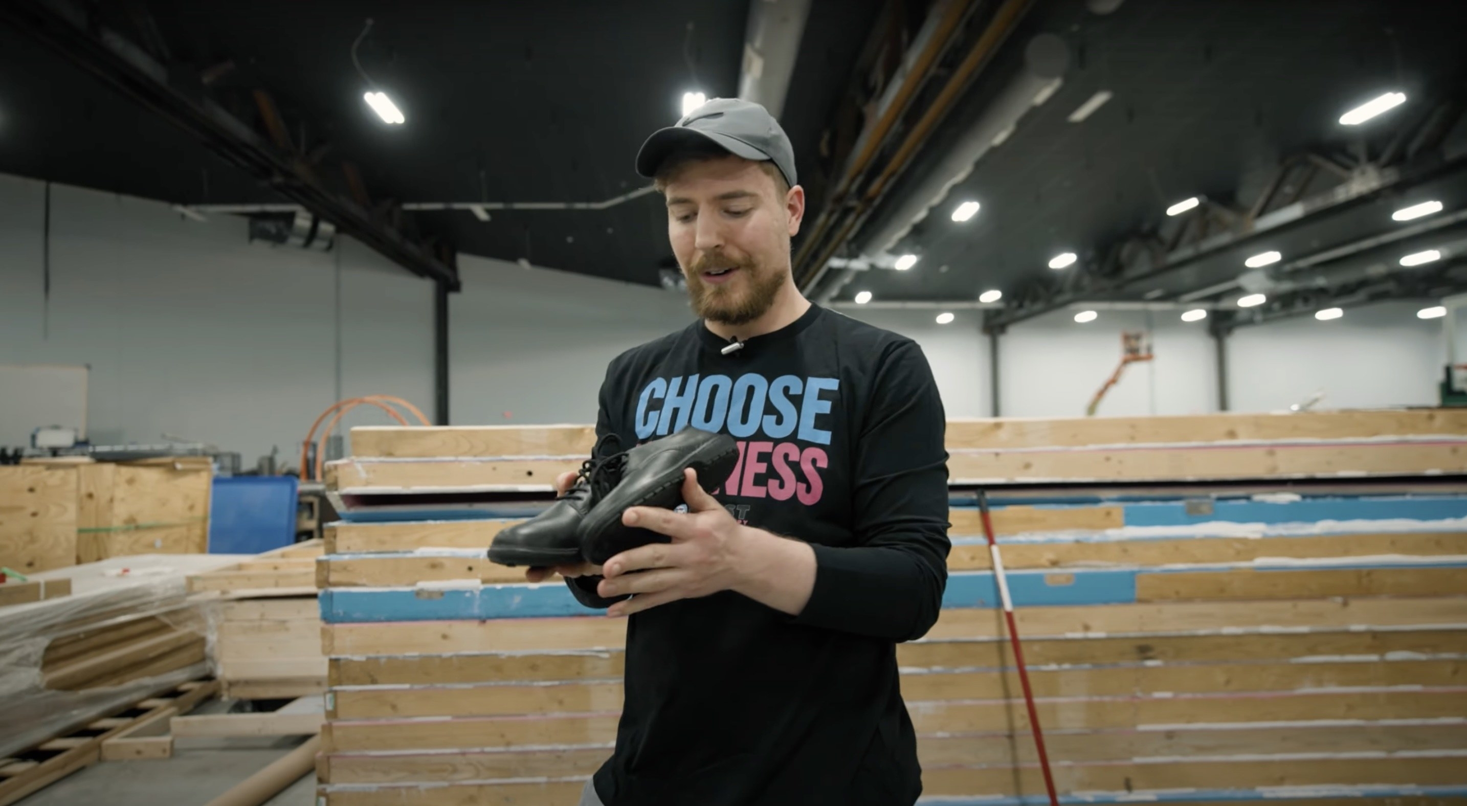 MrBeast inside a warehouse holding a pair of shoes