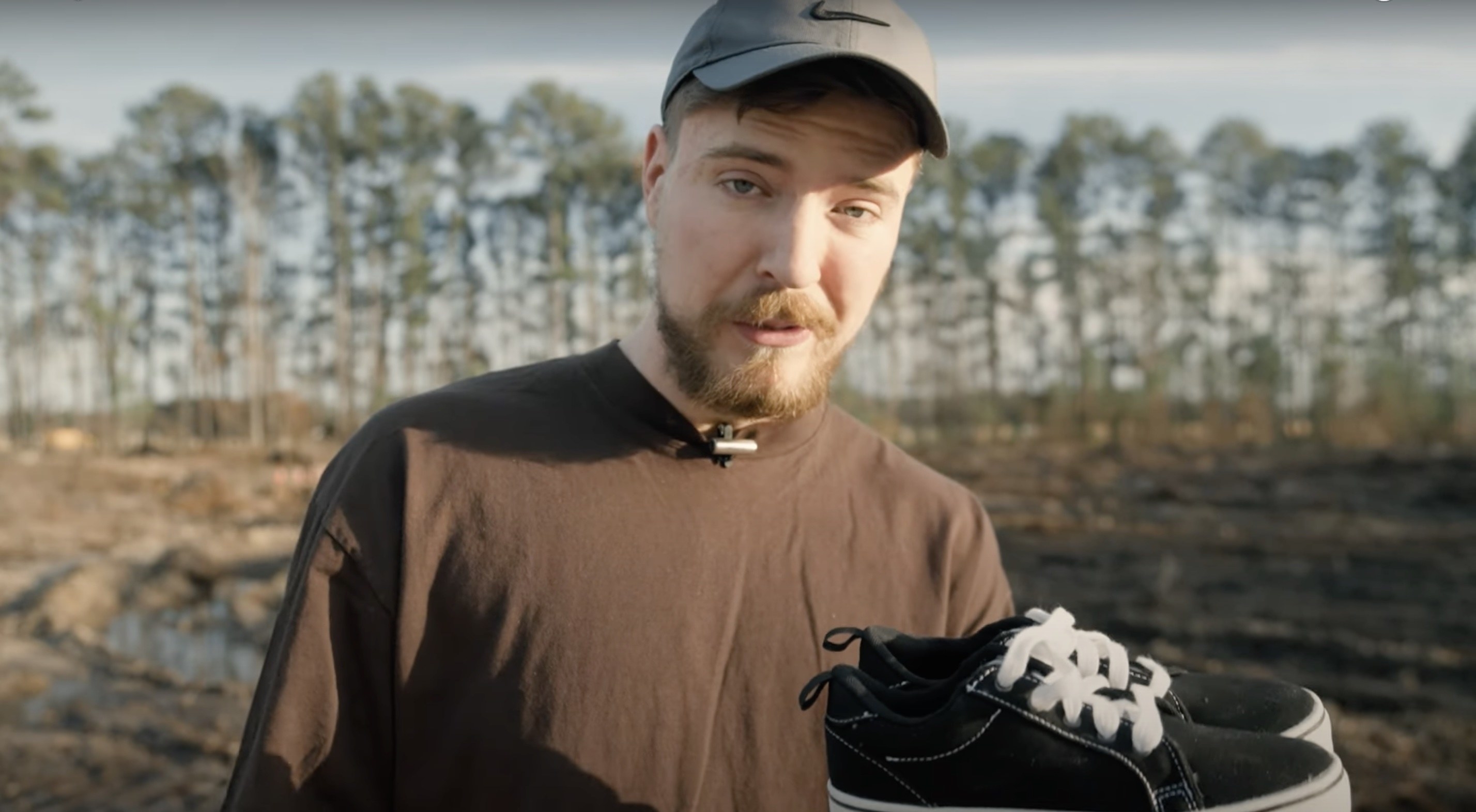 MrBeast walking outside holding a pair of shoes