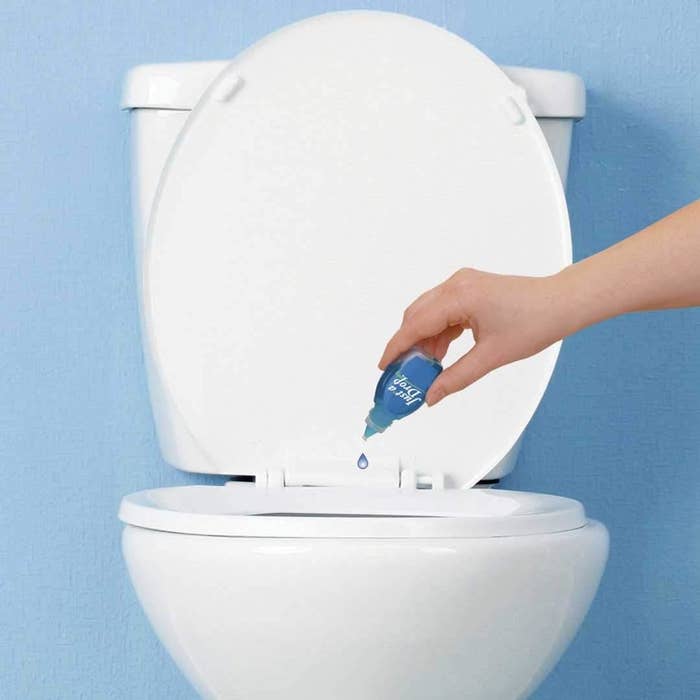 a bottle of the drops being put into a toilet bowl