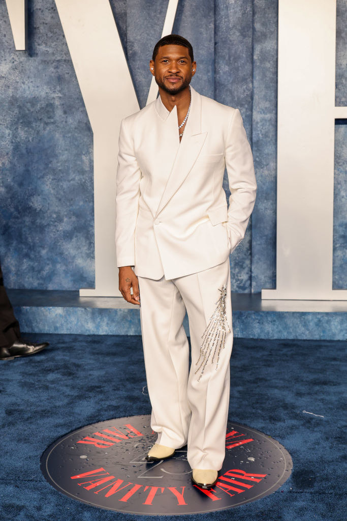 Usher on the blue carpet of the Vanity Fair after party wearing an asymmetrical suit