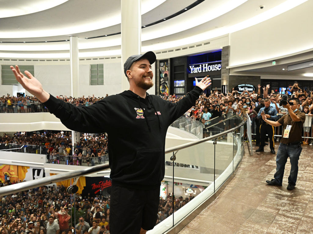 MrBeast posing for a photo in a crowded building