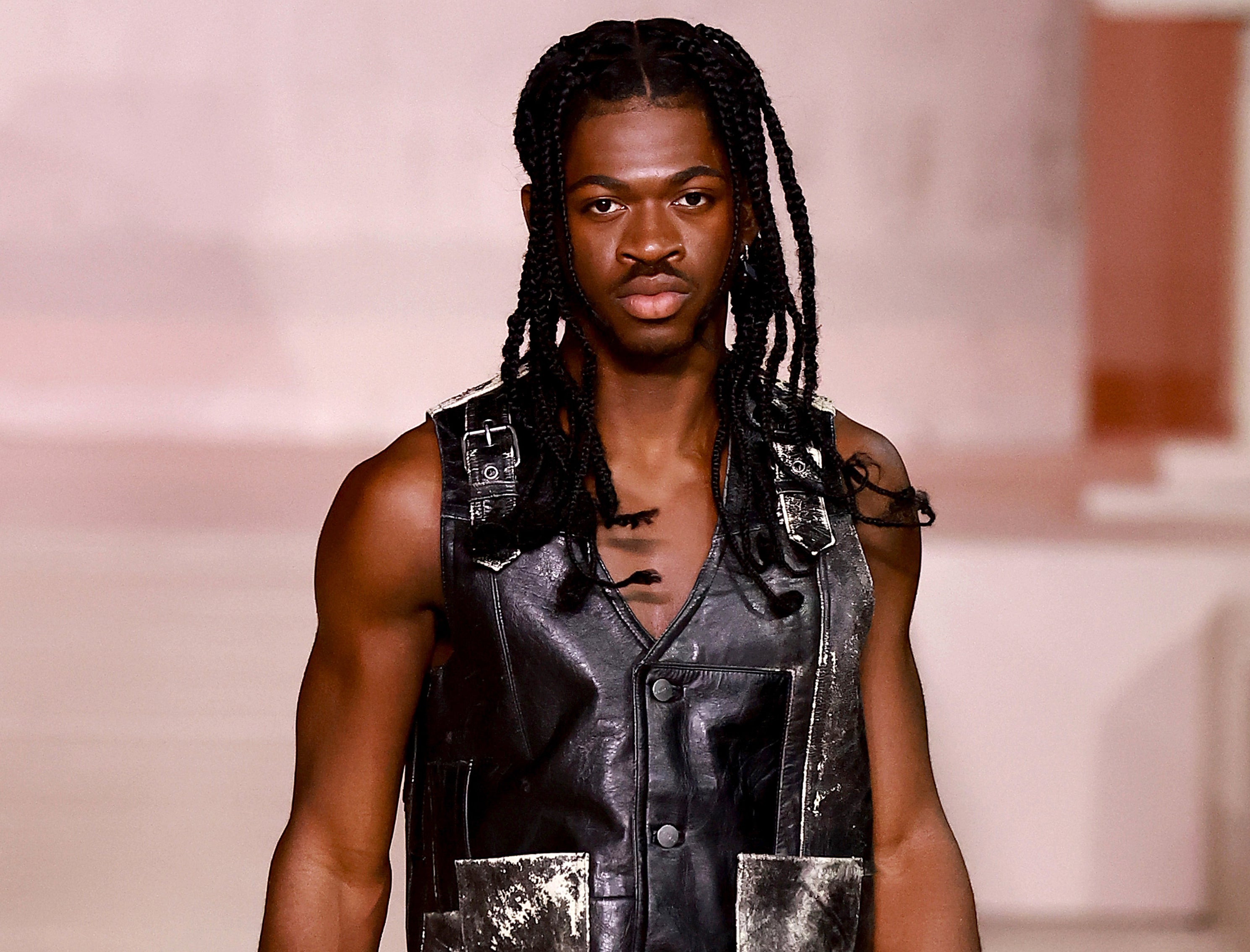 A close-up of Lil Nas in a leather sleeveless vest