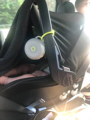 Reviewer photo of the white noise machine attached to a car seat