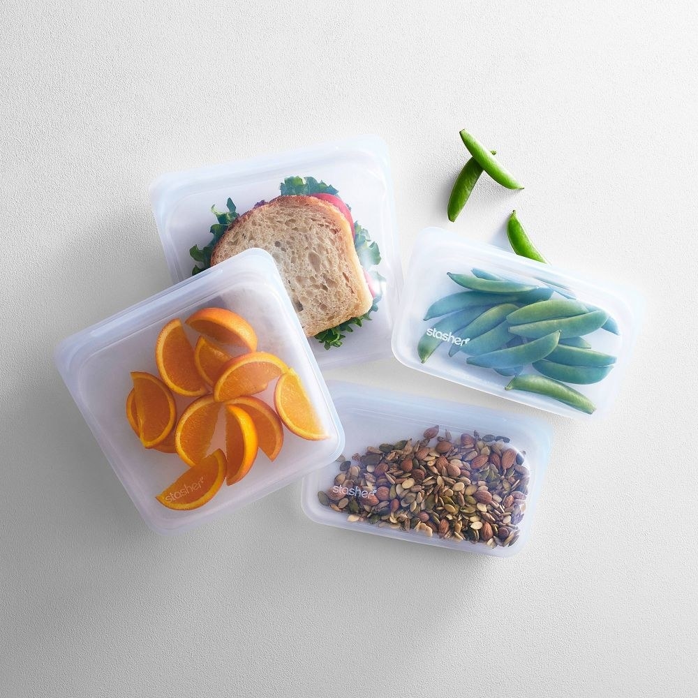 the product shot of various bags with nuts and oranges and sandwich inside