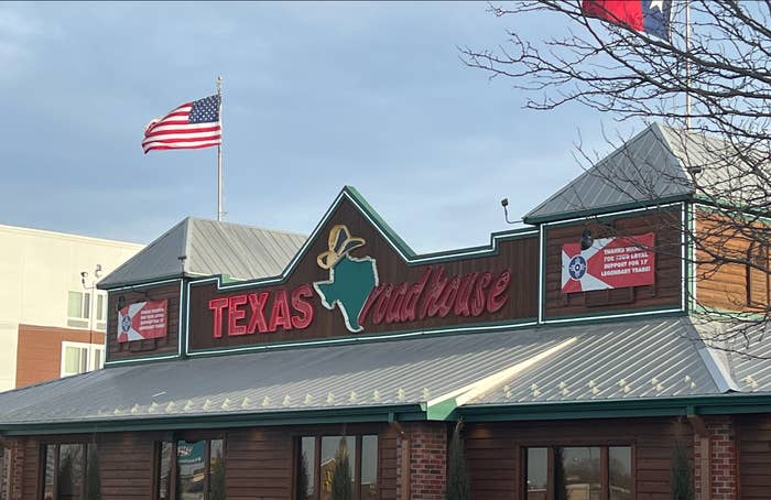 The exterior of a Texas Roadhouse which features the outline of the state of Texas wearing a cowboy hat