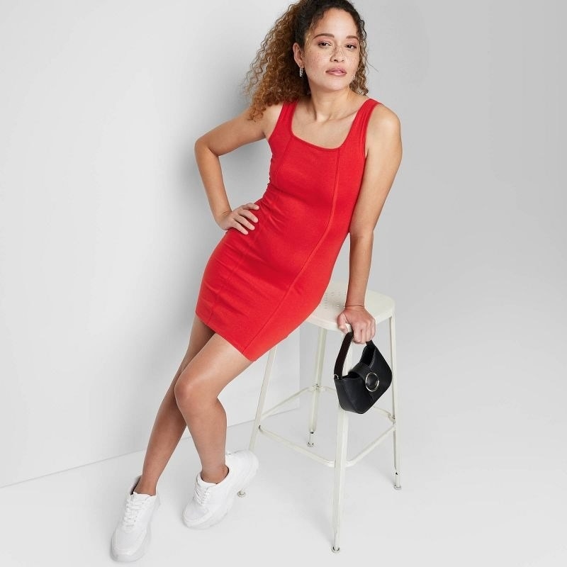model wearing sleeveless red seamed bodycon dress