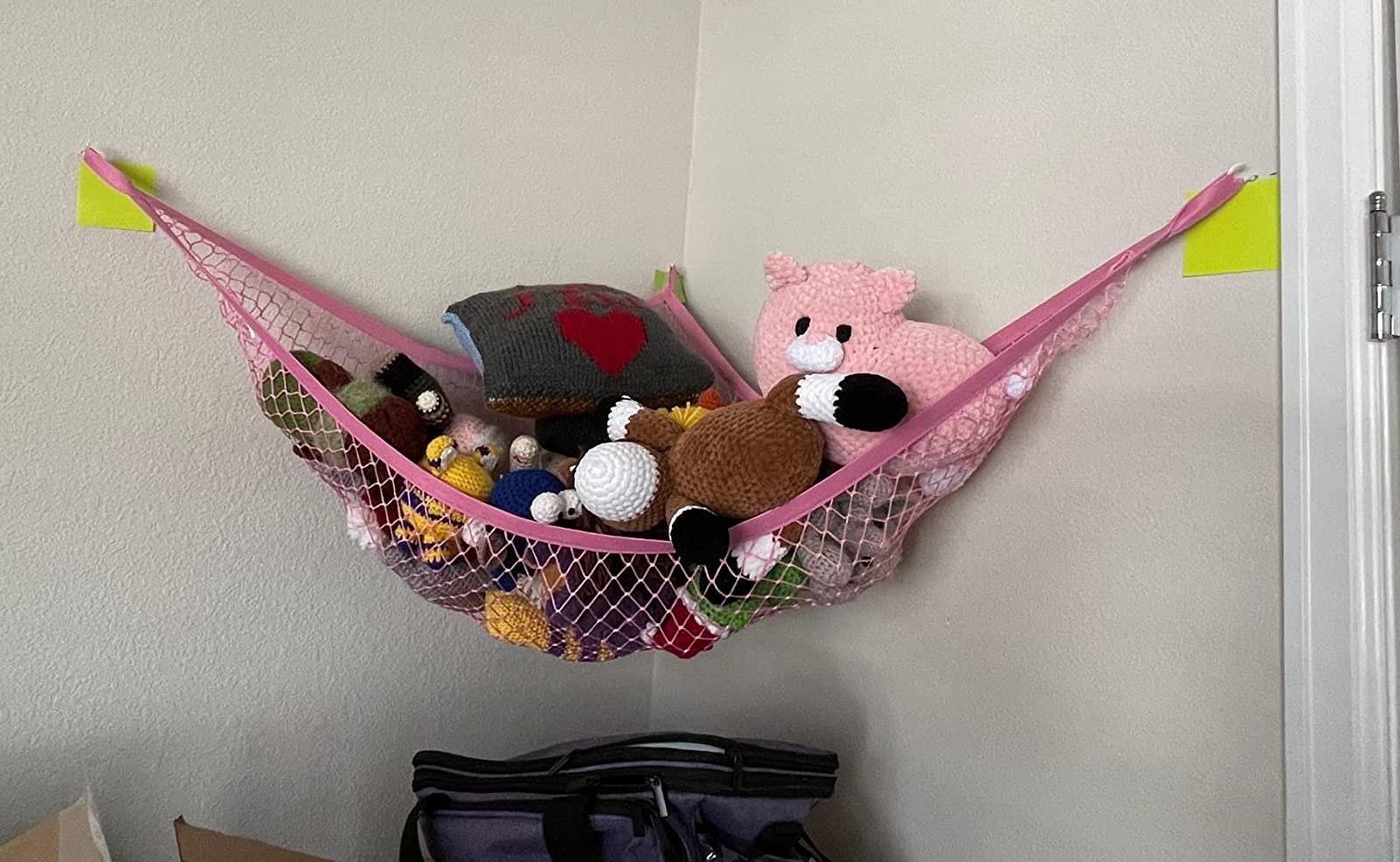 Reviewer image of stuffed animals in a pink hammock hanging in a room corner