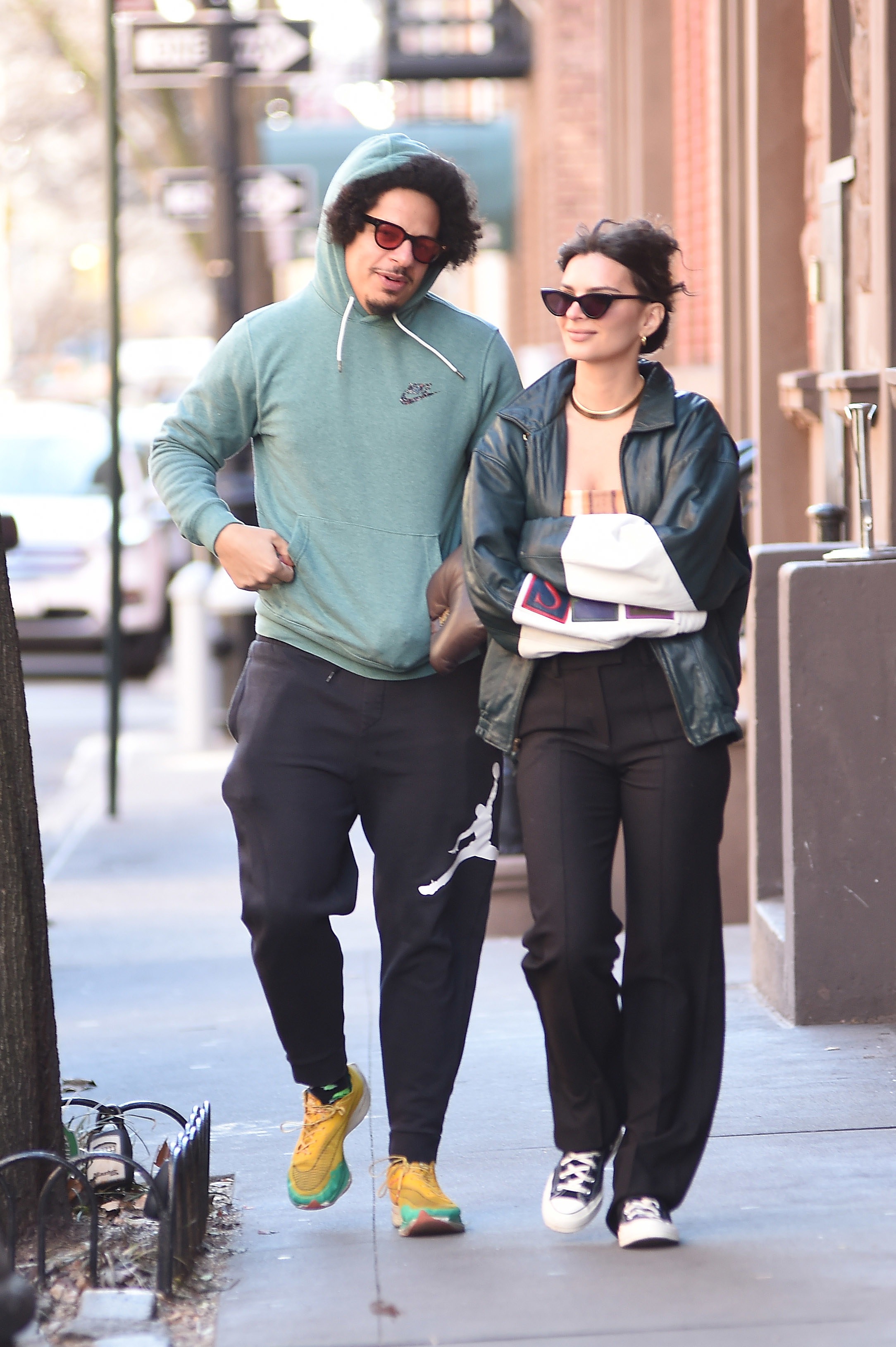 Eric and Emily walking down the sidewalk while dressed casually