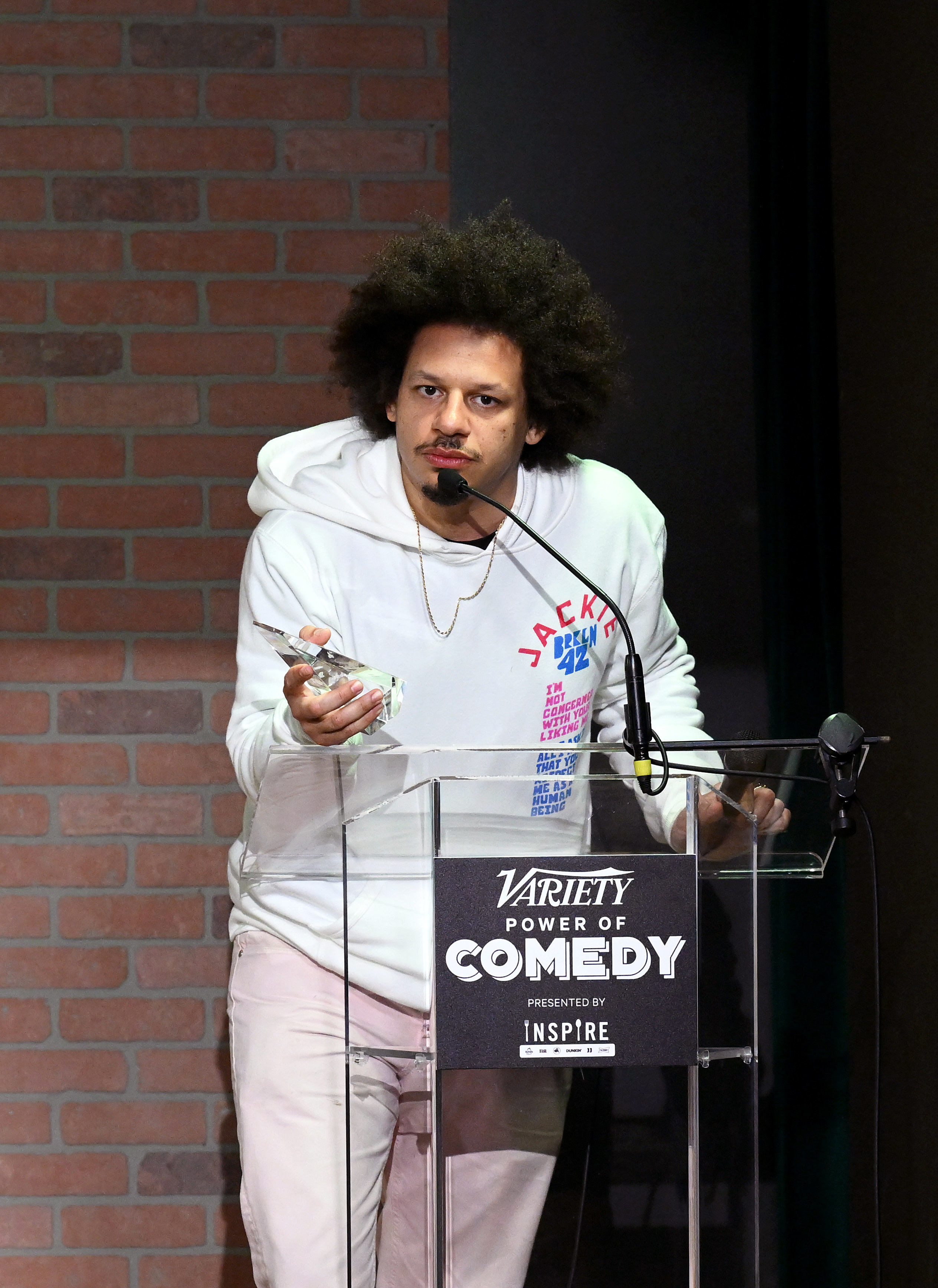 Eric speaking at a podium that says Variety Power of Comedy presented by Inspire