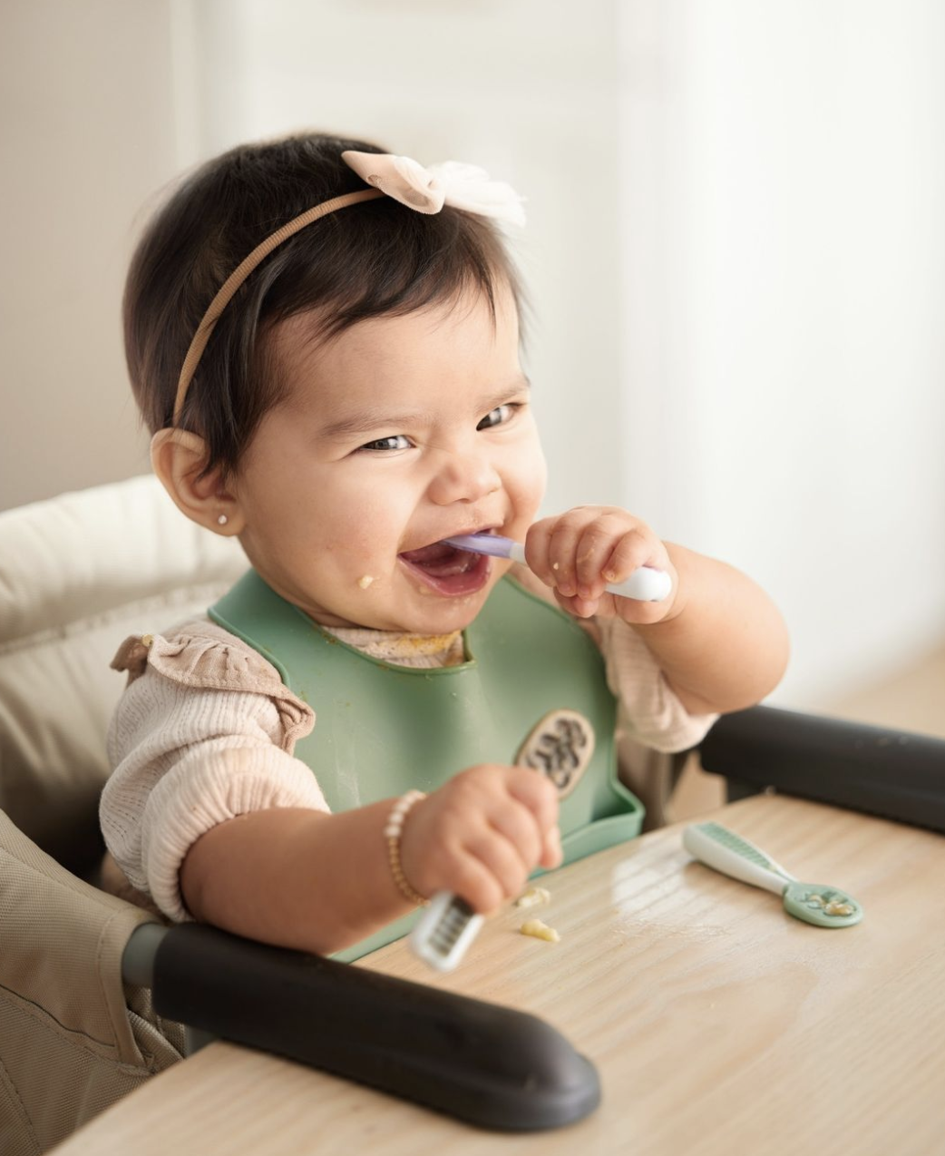 baby using the spoons to eat