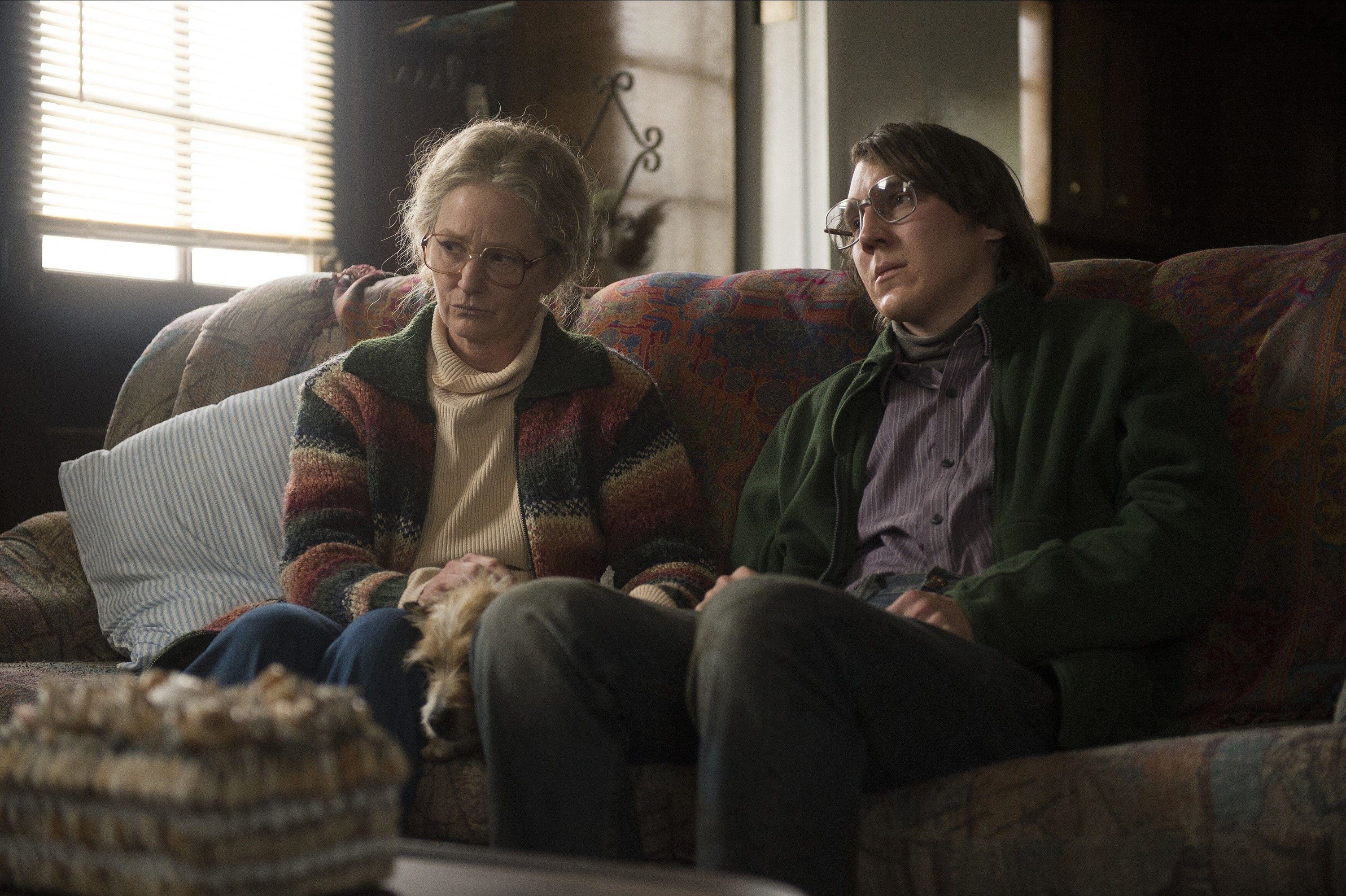 Melissa Leo and Paul Dano sit on an old couch