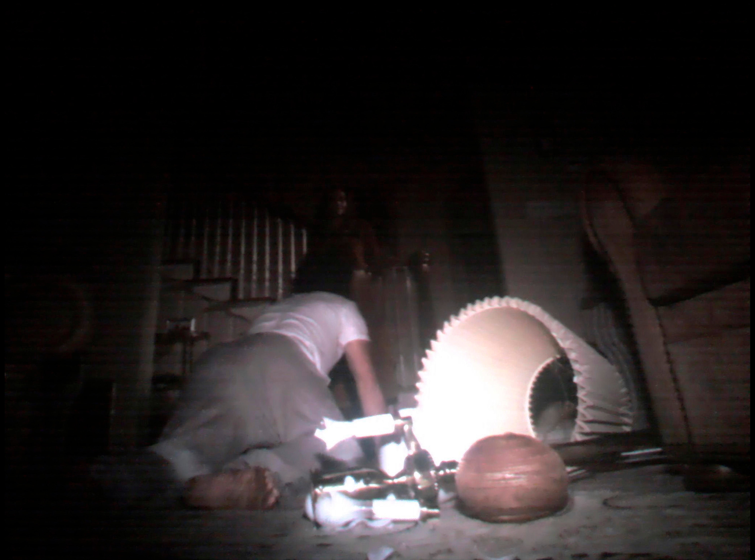 A man crawls before a smiling woman on a staircase in a beaten-up living room