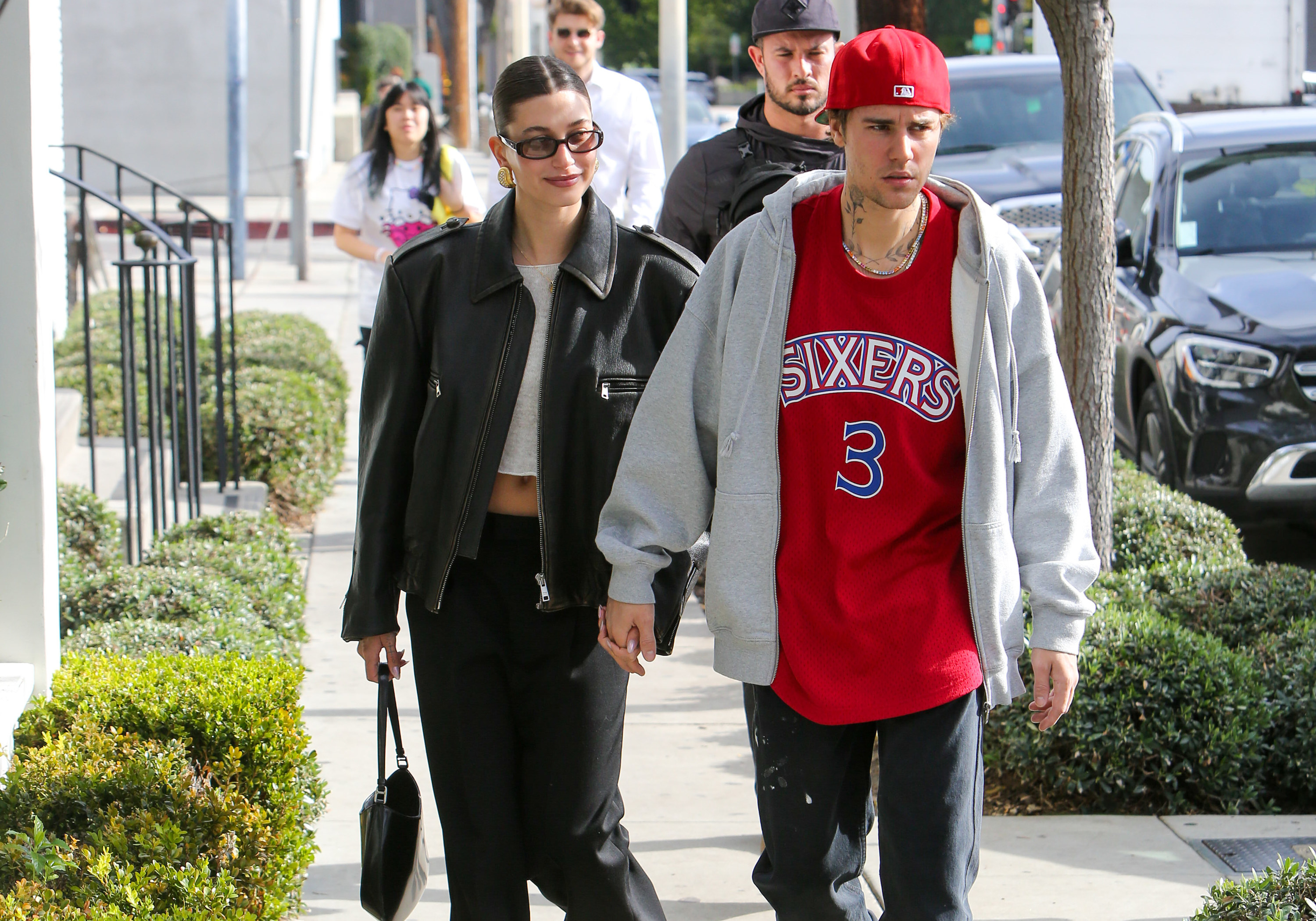 The couple walking down a sidewalk as they holds hands