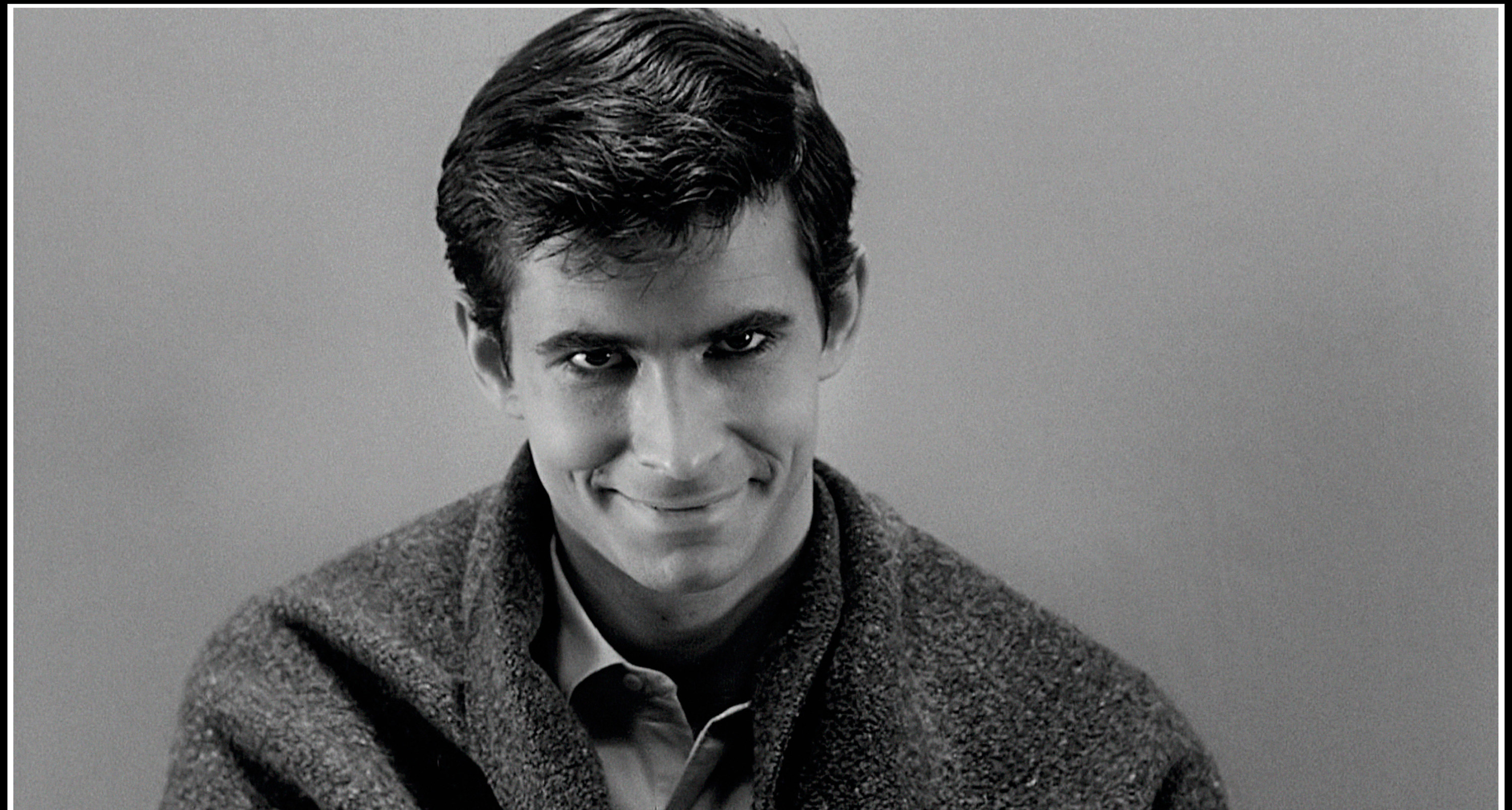 Anthony Perkins showcases a wicked grin while staring directly to camera