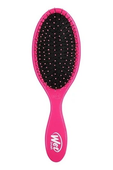 Pink hair brush against a white background