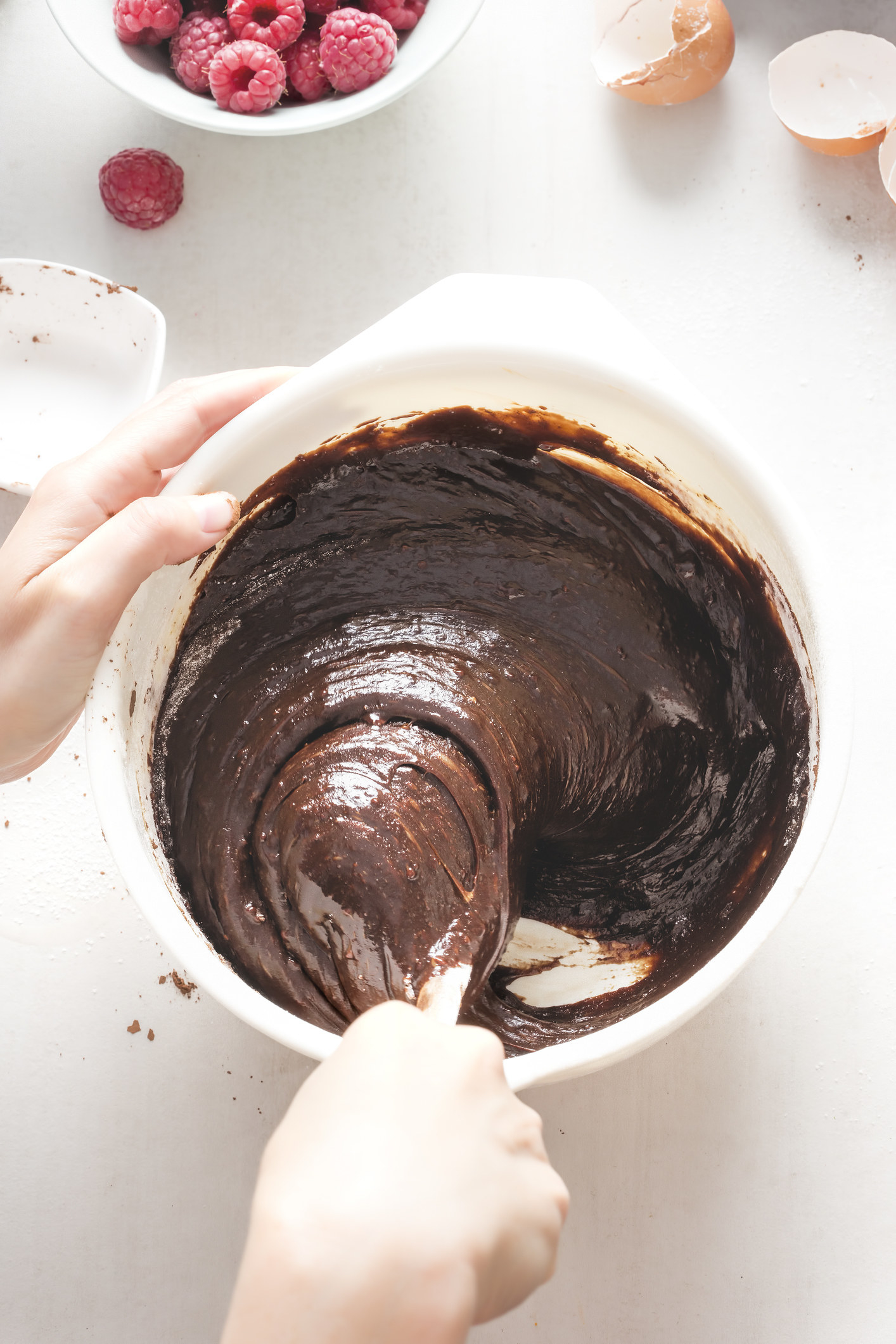 Mixing chocolate brownie batter in a bowl by hand