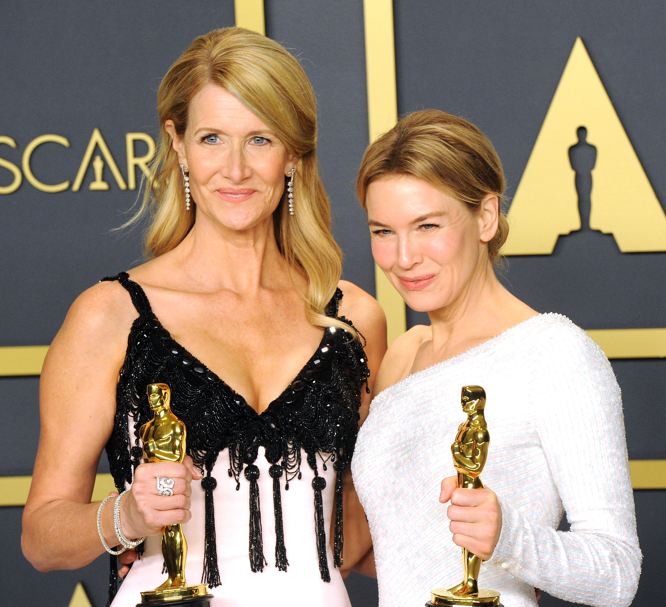 Laura Dern and Renee Zellweger holding their Oscars backstage