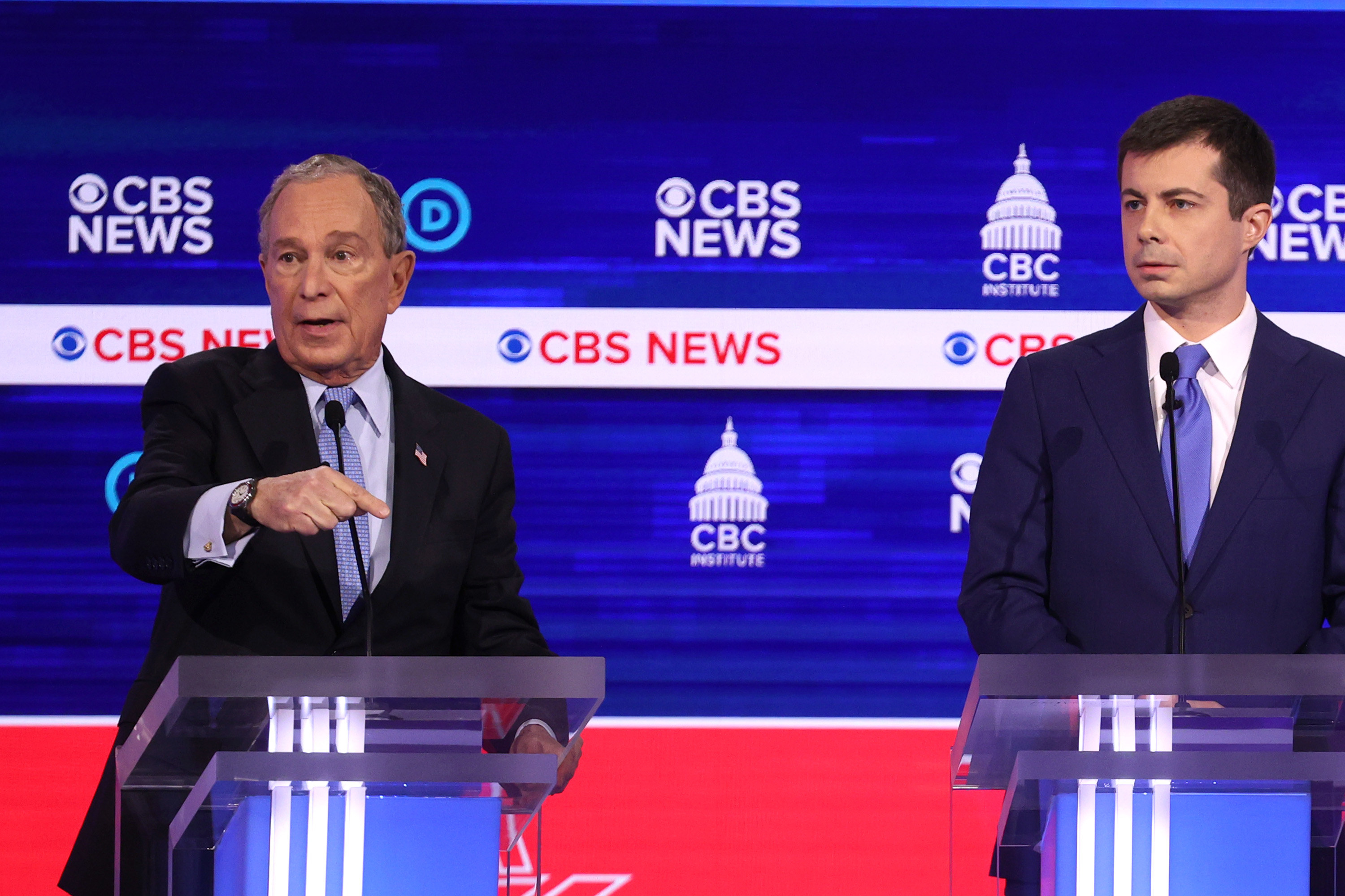 Mike speaking during a debate while standing next to Pete Buttigieg