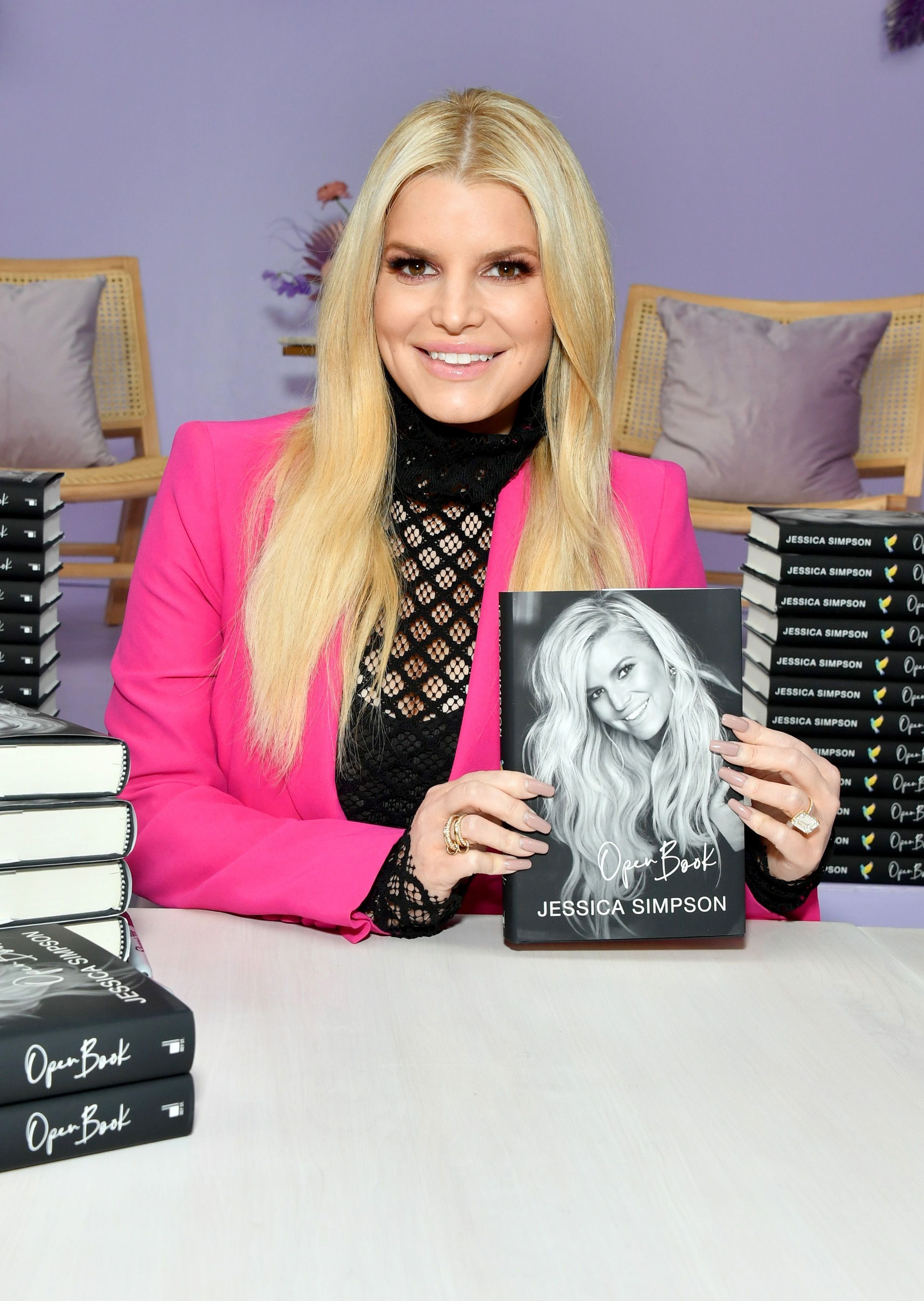 Jessica holds up her book at a book signing