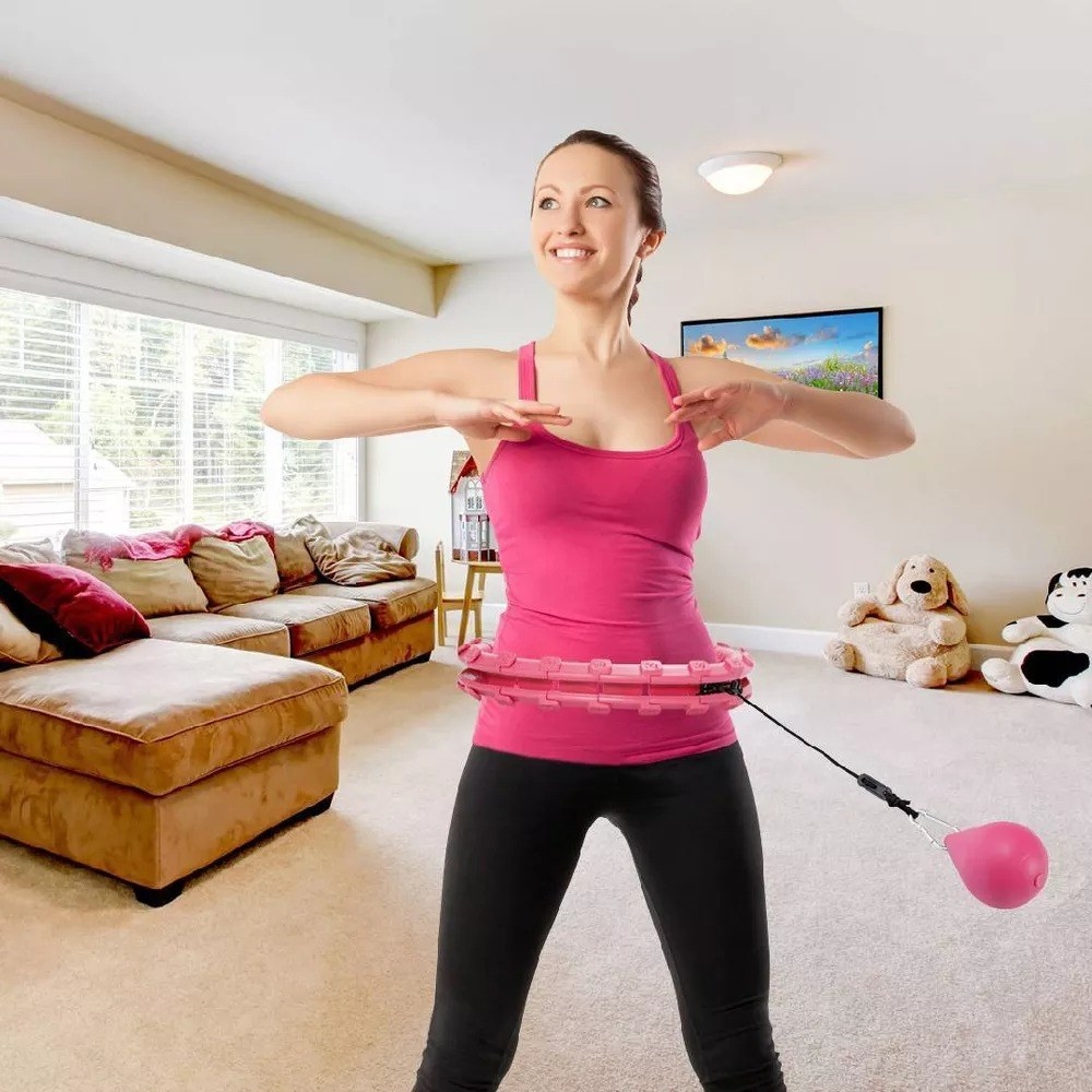 model working out while wearing a pink weighted hoop on hips