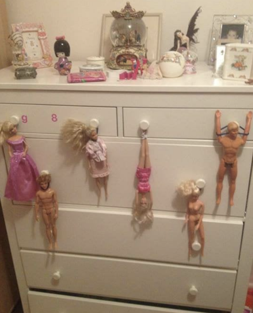 Barbies hanging from drawers