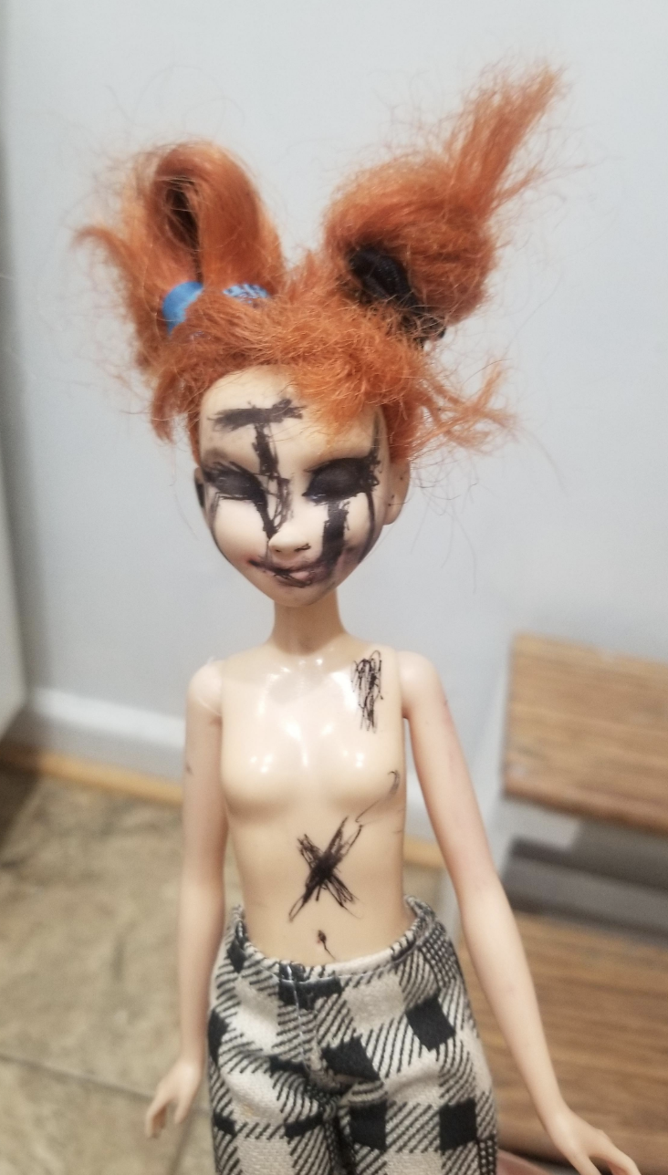 A doll with writing all over it