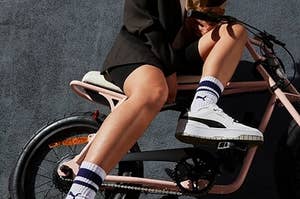 Person wears Puma's Cali Dream sneakers while on a bike