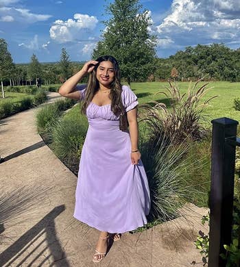 a reviewer wearing the dress in purple