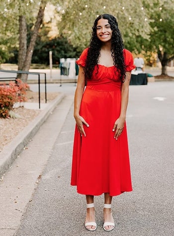 a reviewer wearing the dress in red
