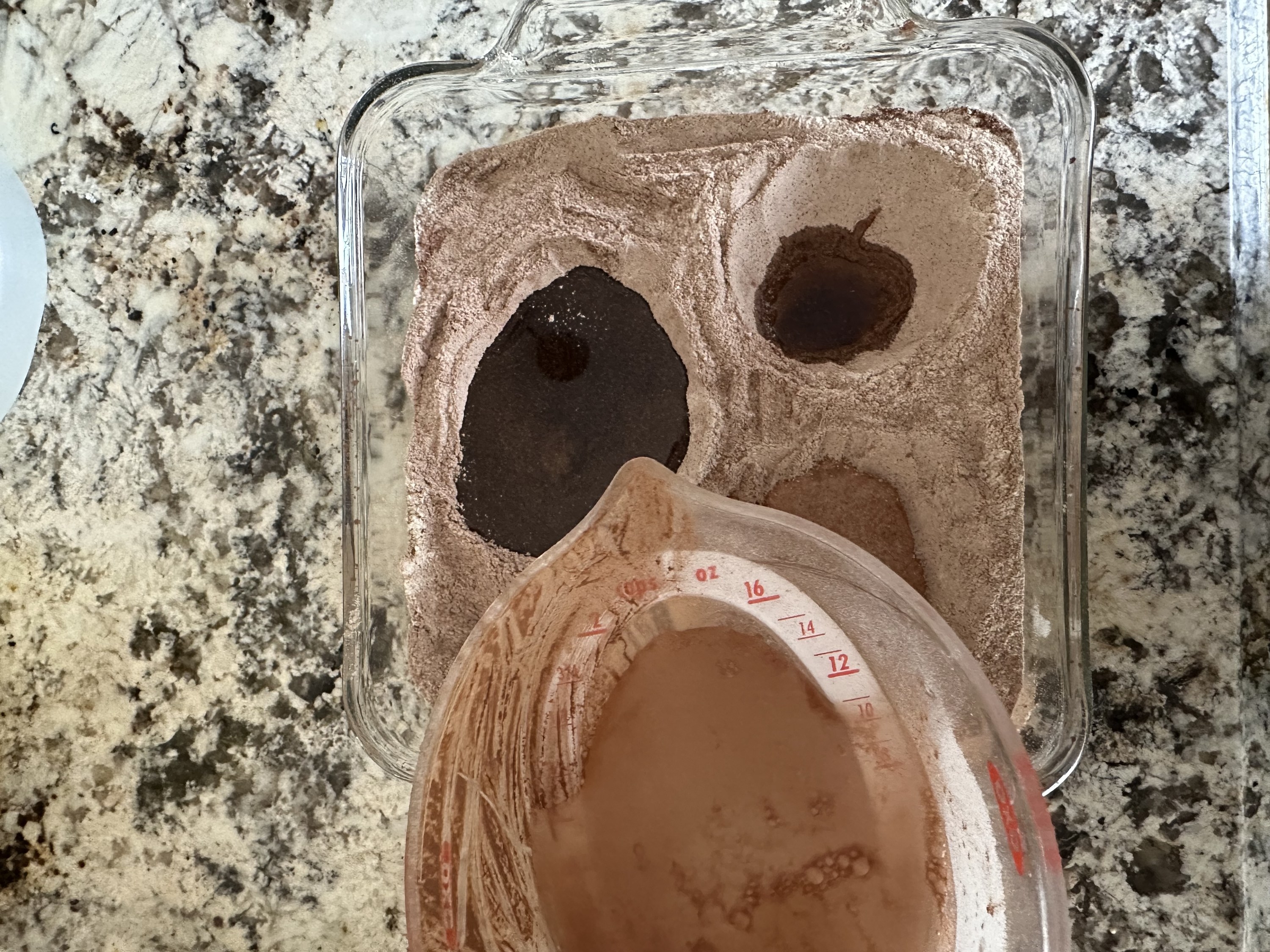 the author pouring a cup of water over the cake mixture