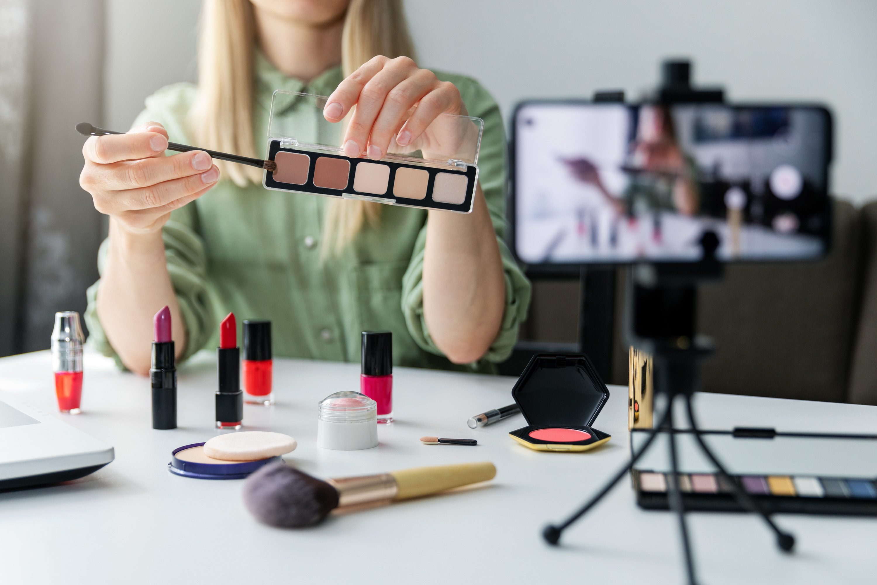 beauty blogger showing make up products to the camera