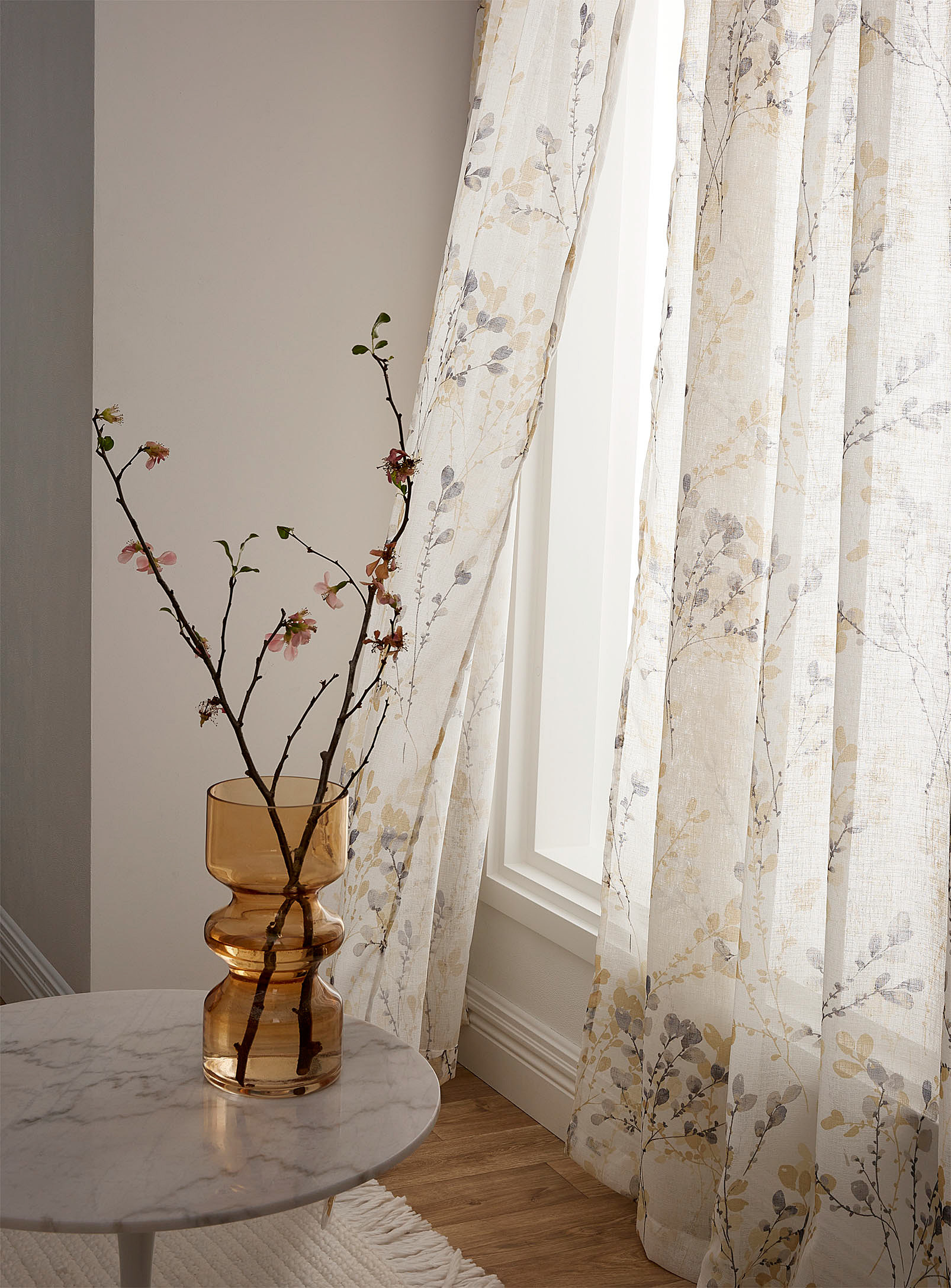 a pair of sheer curtains on a bright window
