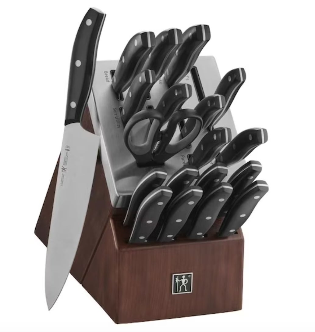 A set of metal knives with black handles in a wooden block