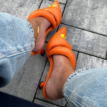 reviewer wearing the mules in orange
