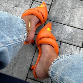 reviewer wearing the mules in orange