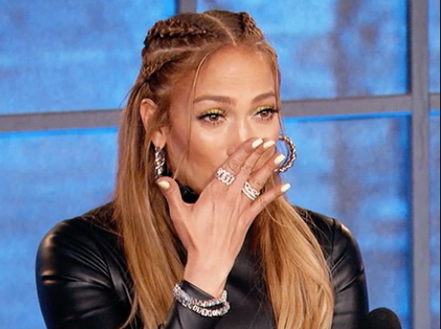 J.Lo covering her mouth with her hand