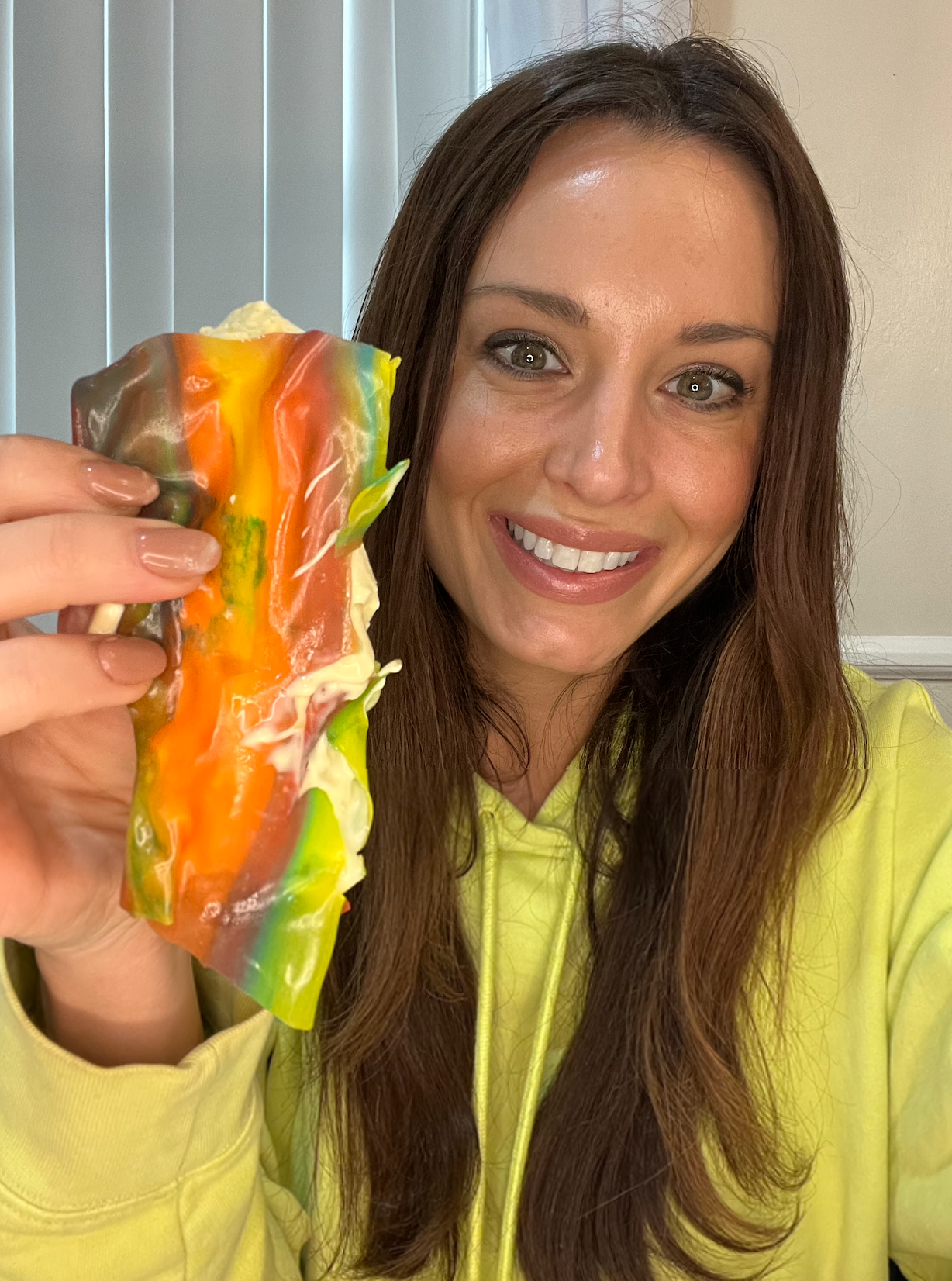 Smiling woman holding up Fruit Roll-Up with ice cream