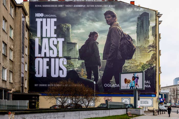 A billboard for the Last of Us featuring Joel and Ellie looking over their shoulder as they walk