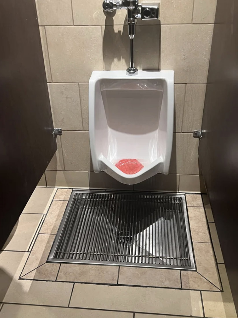 A drain under the urinal for people who miss the toilet