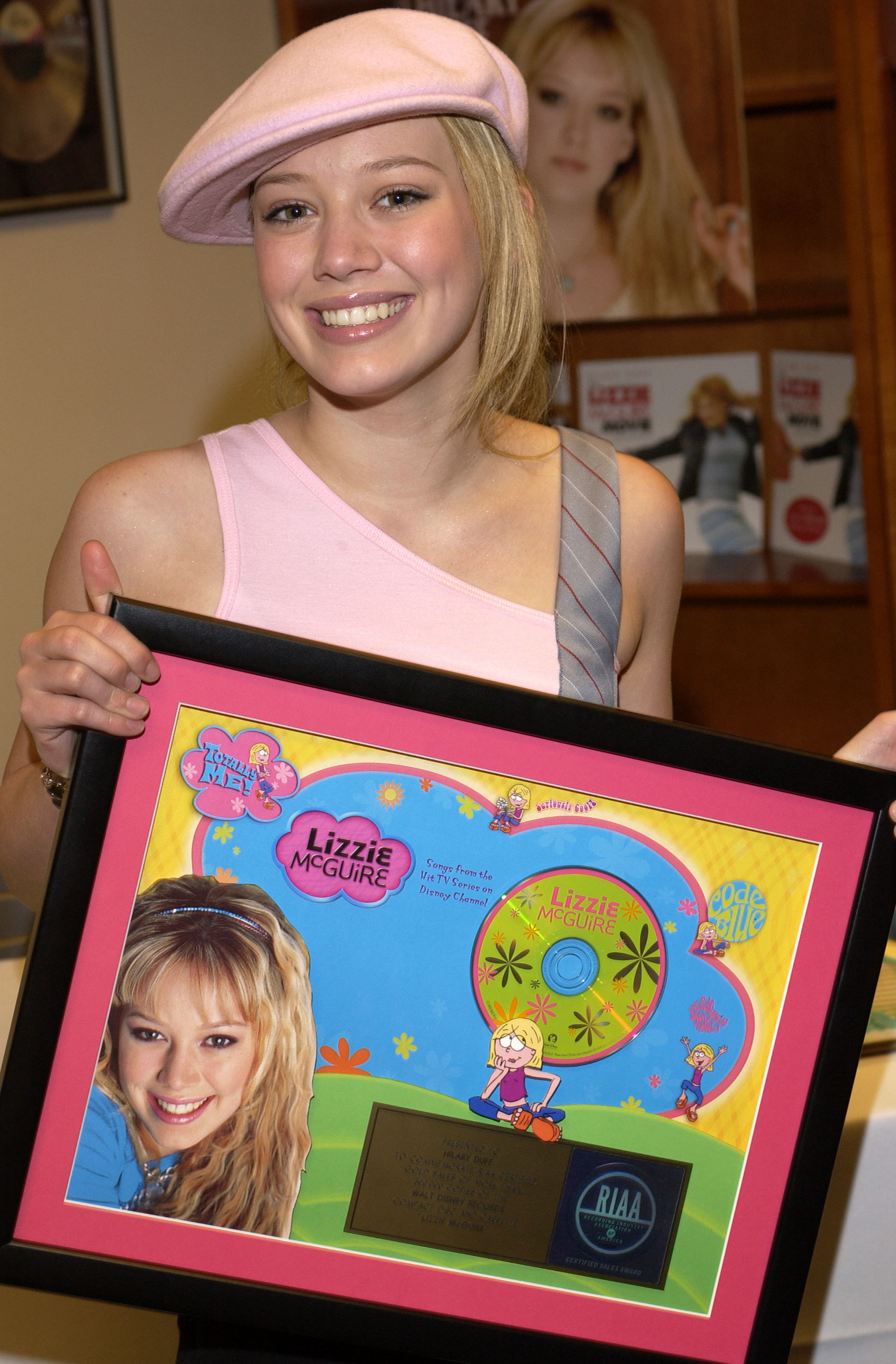 Hilary holding a framed CD of Lizzie McGuire songs