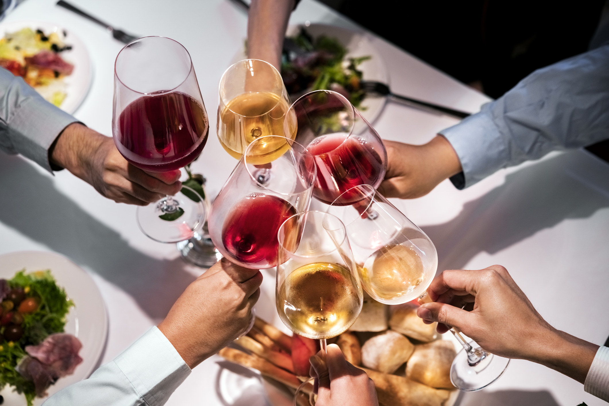 A group of people toasting with wine glasses.