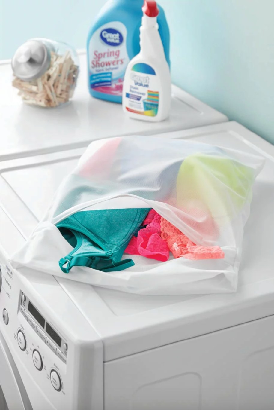 the white mesh bag filled with brightly colored undergarments on top of a white washing machine