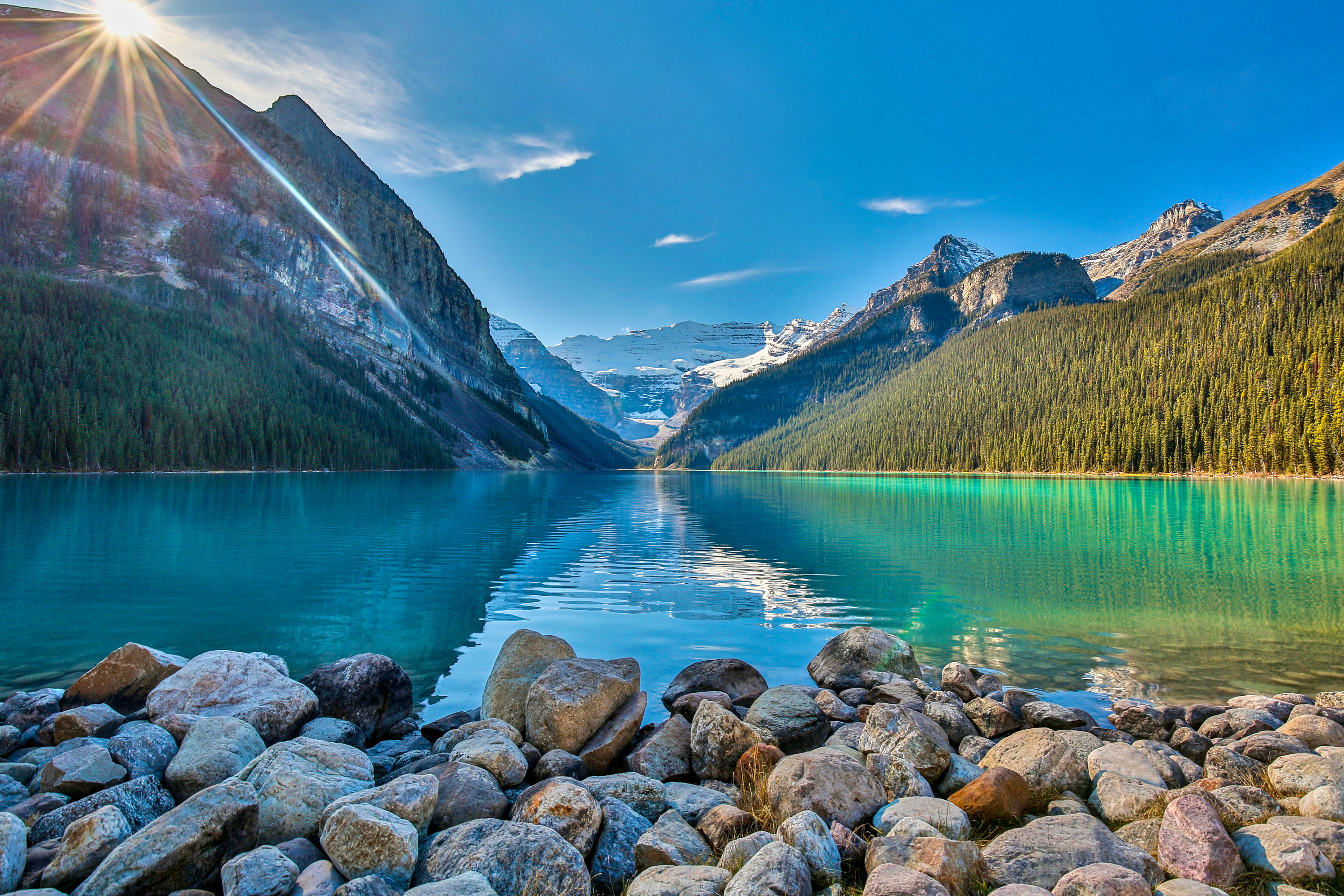 Crystal lake with rocks in front and mountains behind.