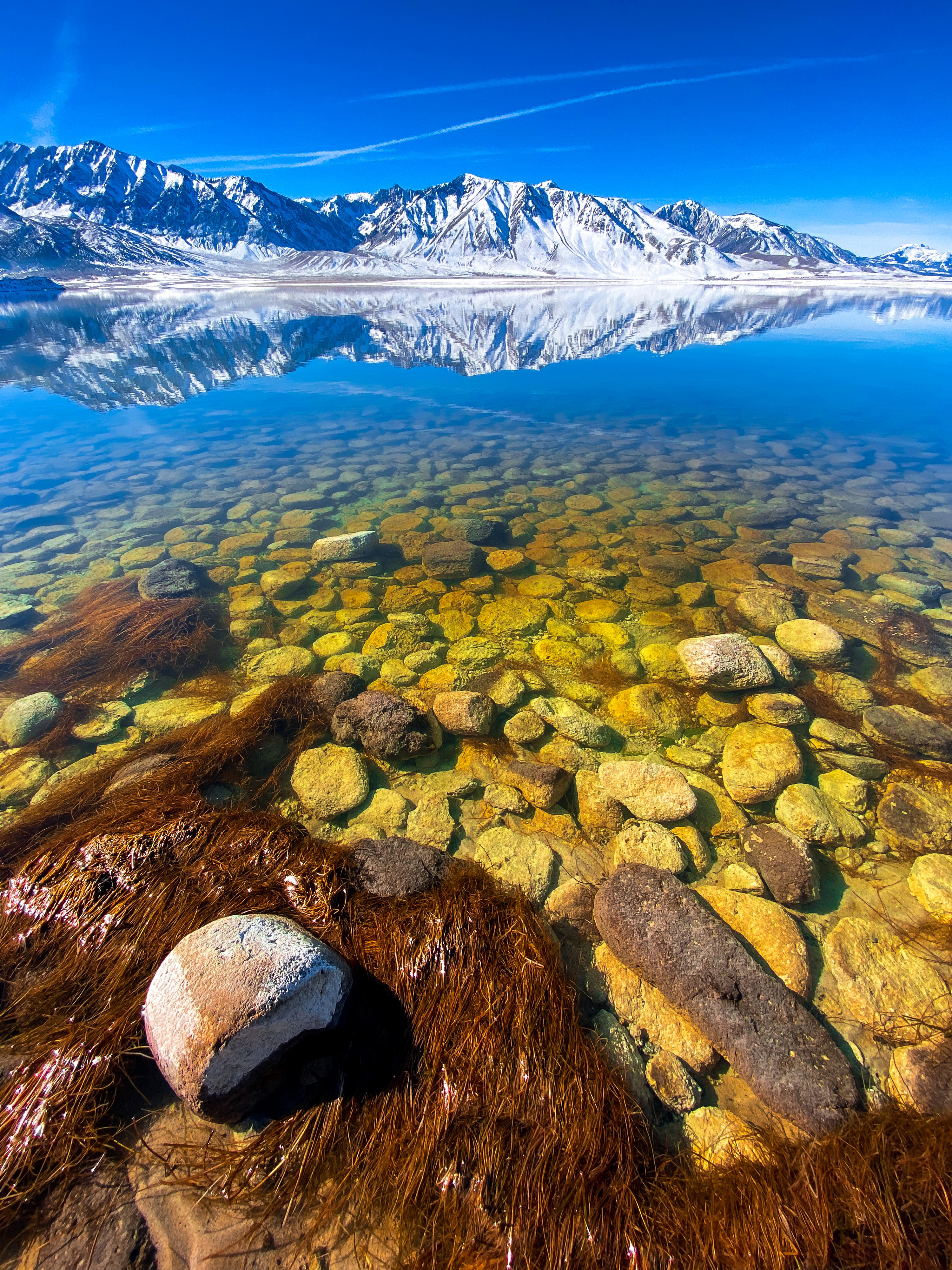 Clear lake with mountains behind